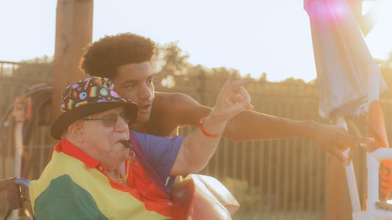 Older camper in a wheelchair pointing at something with a counselor