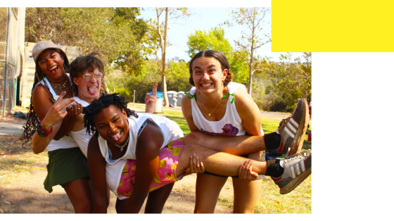 Four counselors laughing while holding each other up
