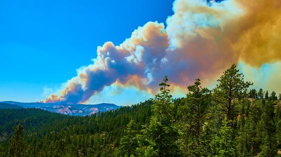 smoke and fire rising from mountain in the distance