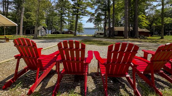 red adirondack chairs with camp in background