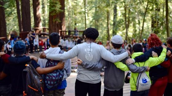 Camp staff and campers in arms in a circle