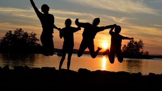 campers jumping at sunset