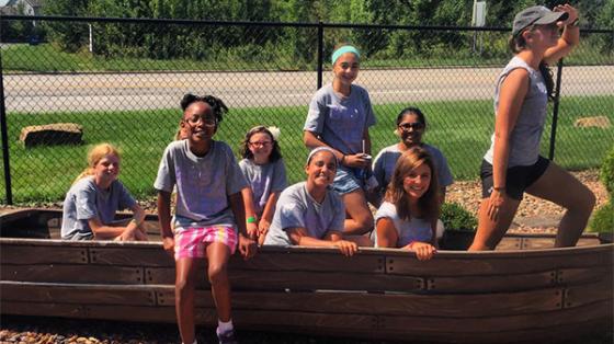 campers posing in a play boat