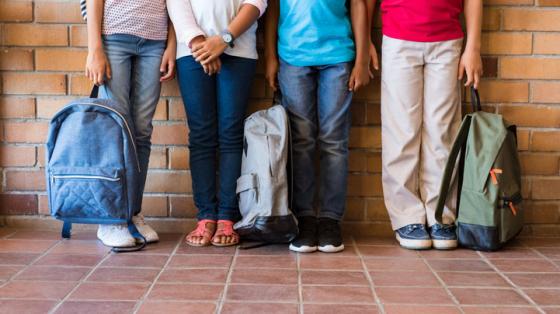 Legs of students against brick wall