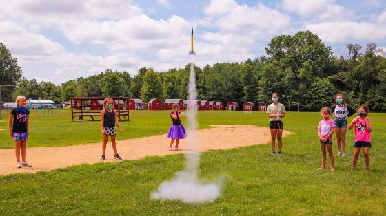 campers in masks launching a rocket