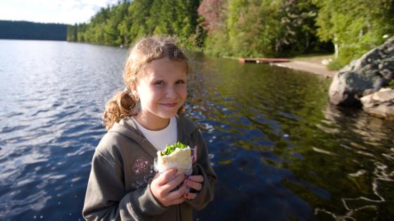 Girl eating by lake