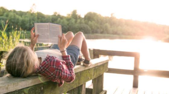 Reading book by lake