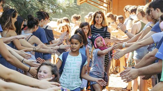 Campers in a line high-fiving staff and other campers