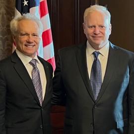 Scott Brody and Steve Baskin standing in front of American flag