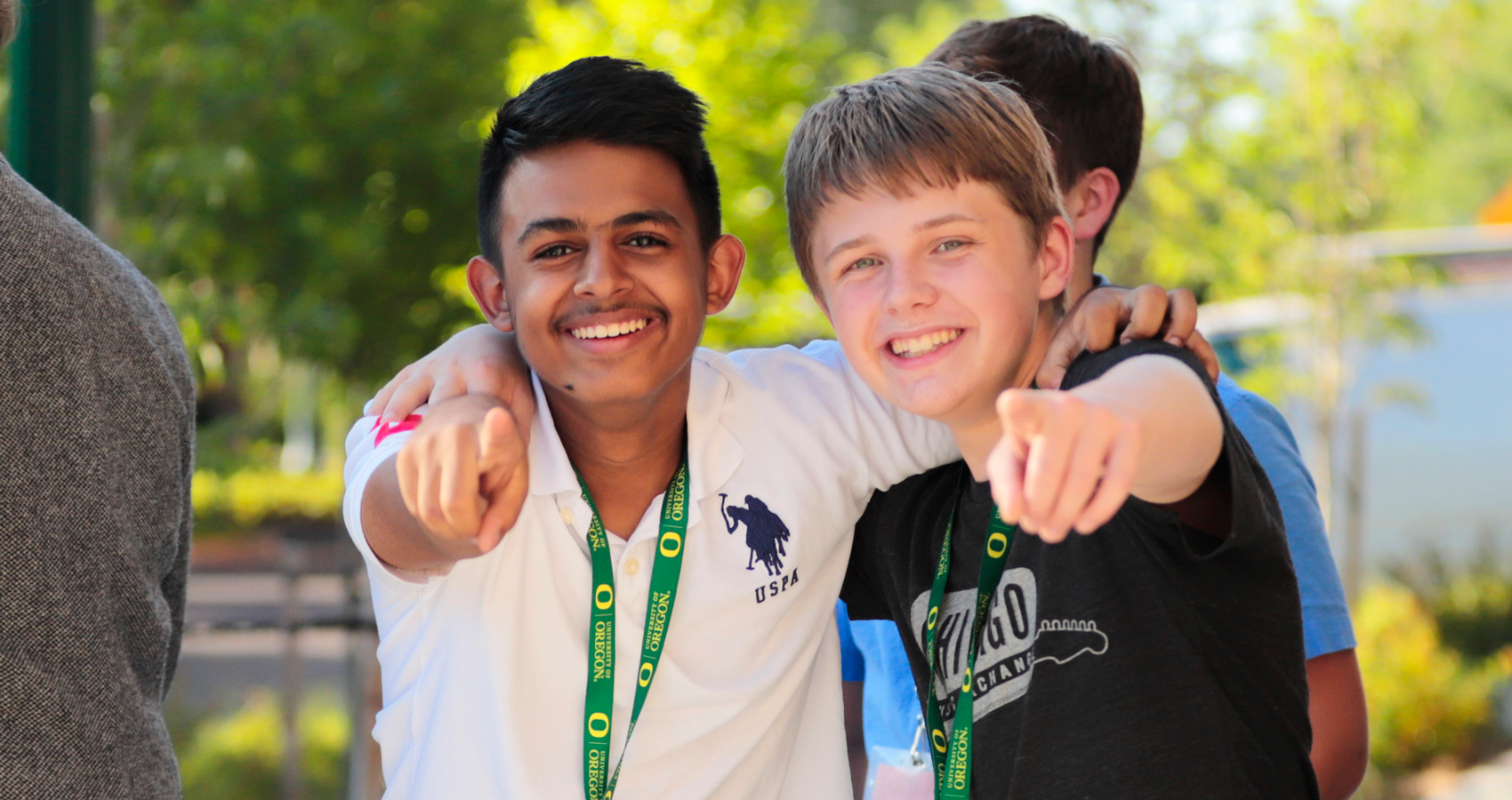 Two campers smiling and pointing at camera