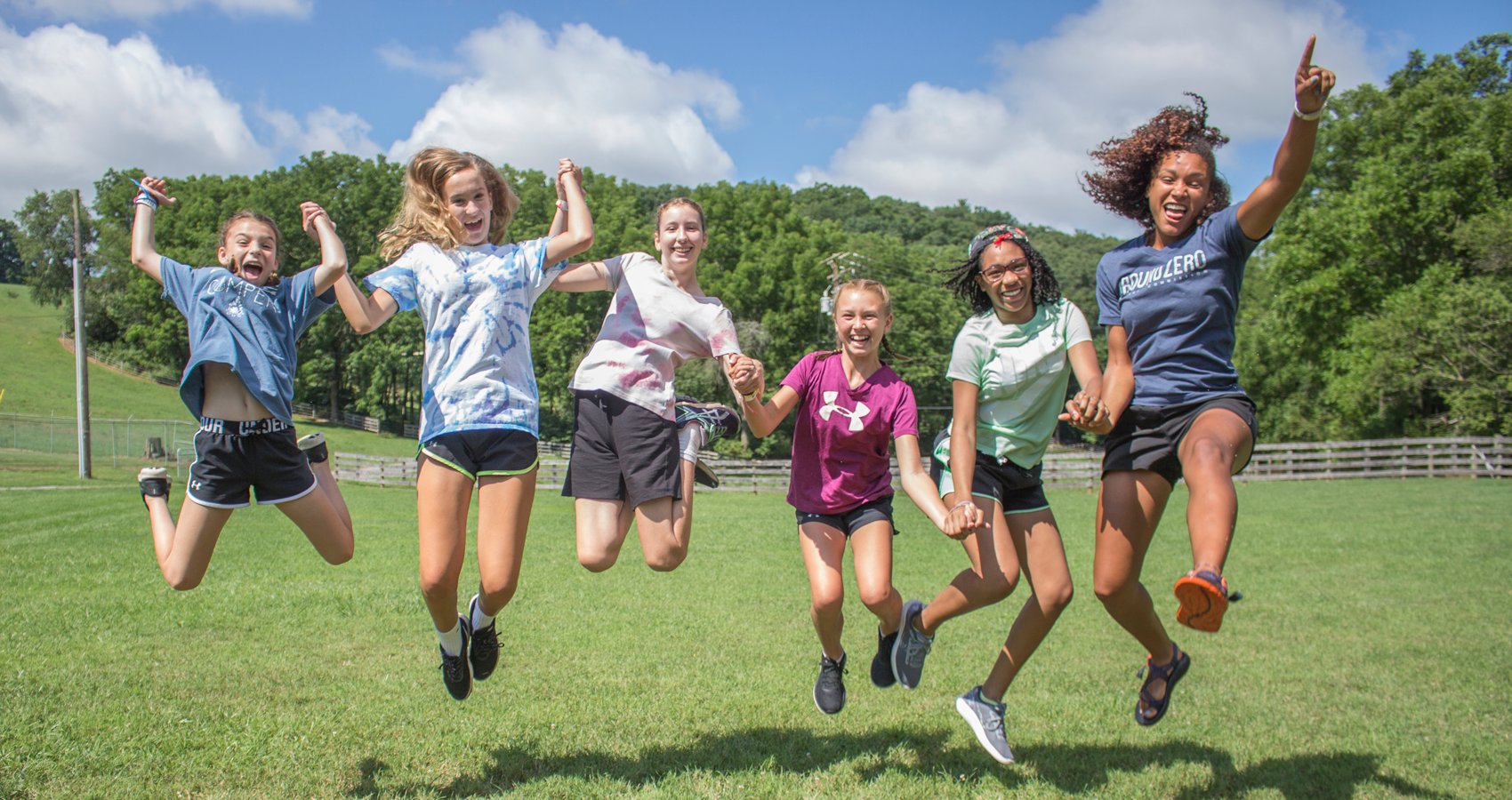 Counselor and campers jumping into the air