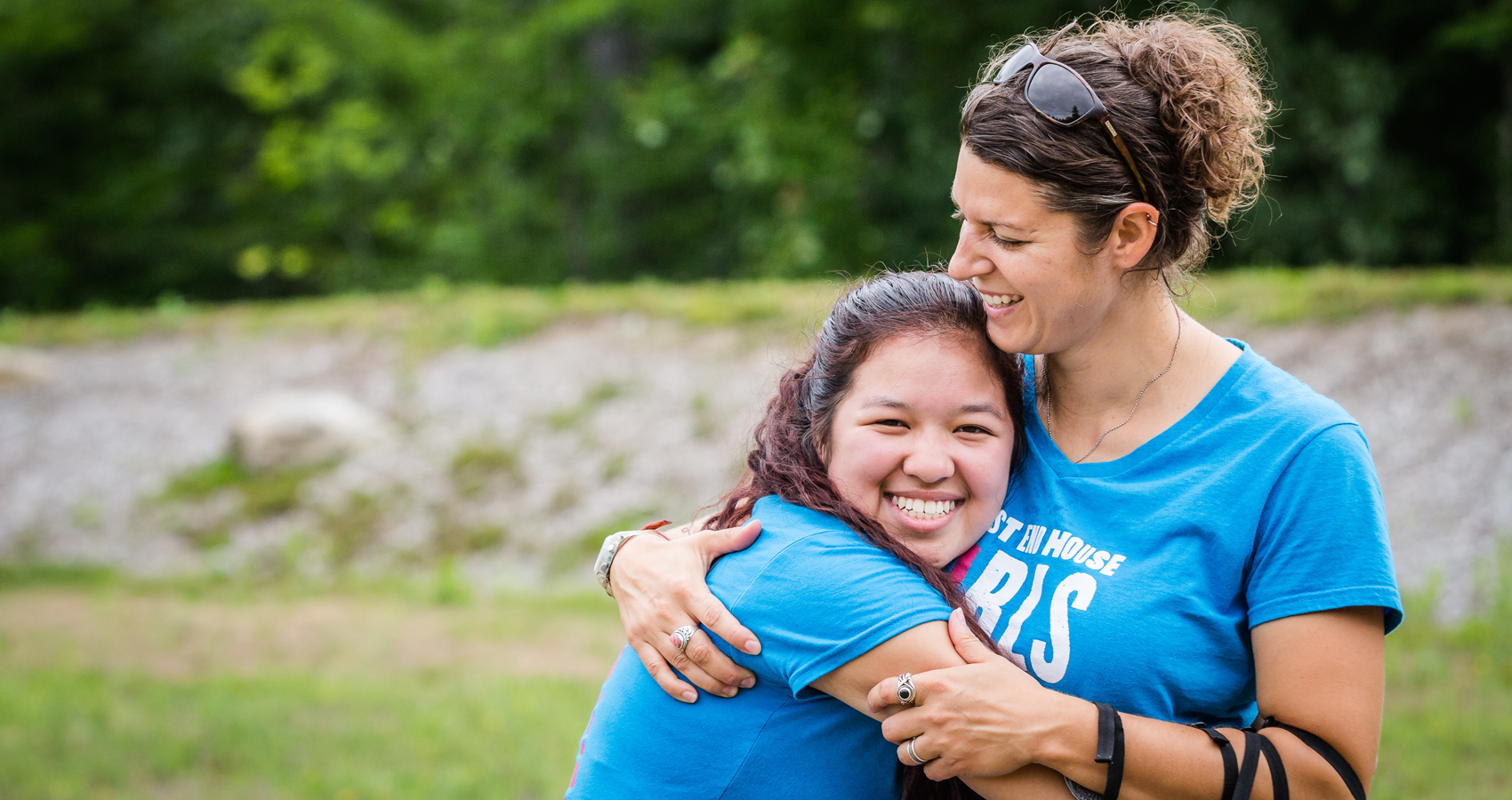 Camp director and former camper hugging