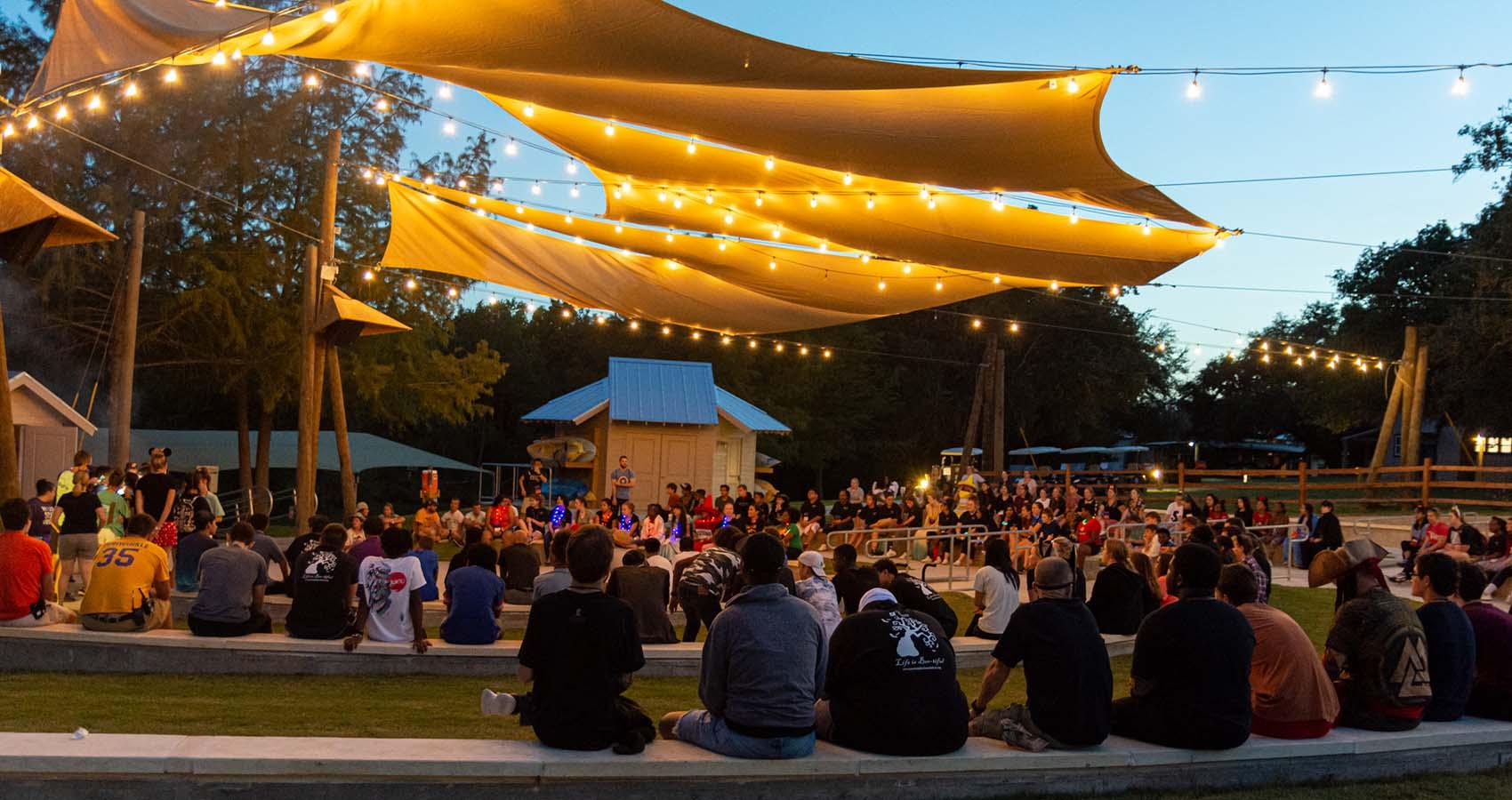 Campers sitting under canopy pavilion 