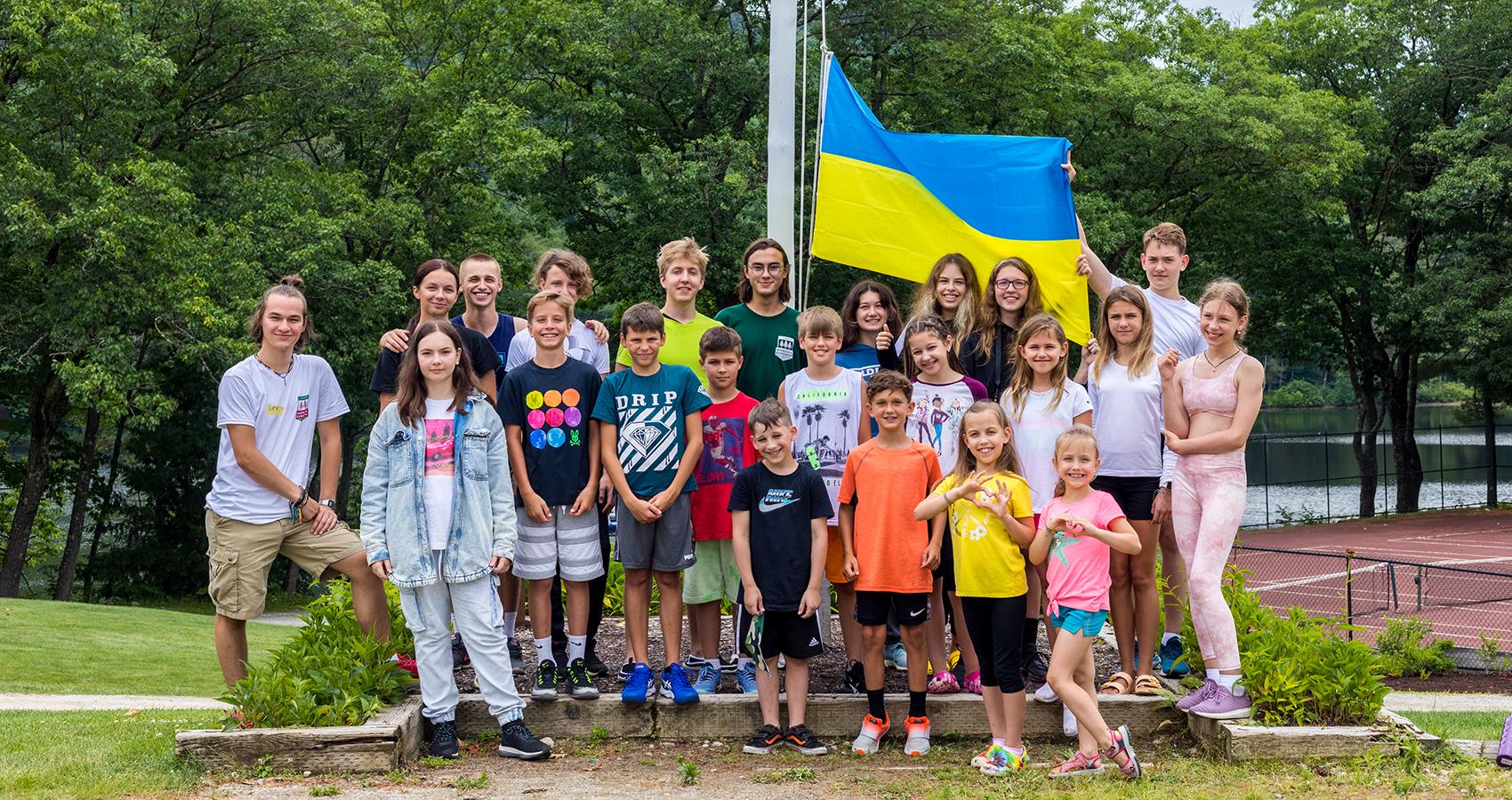 Group of Ukrainian campers standing with Ukrainian flag