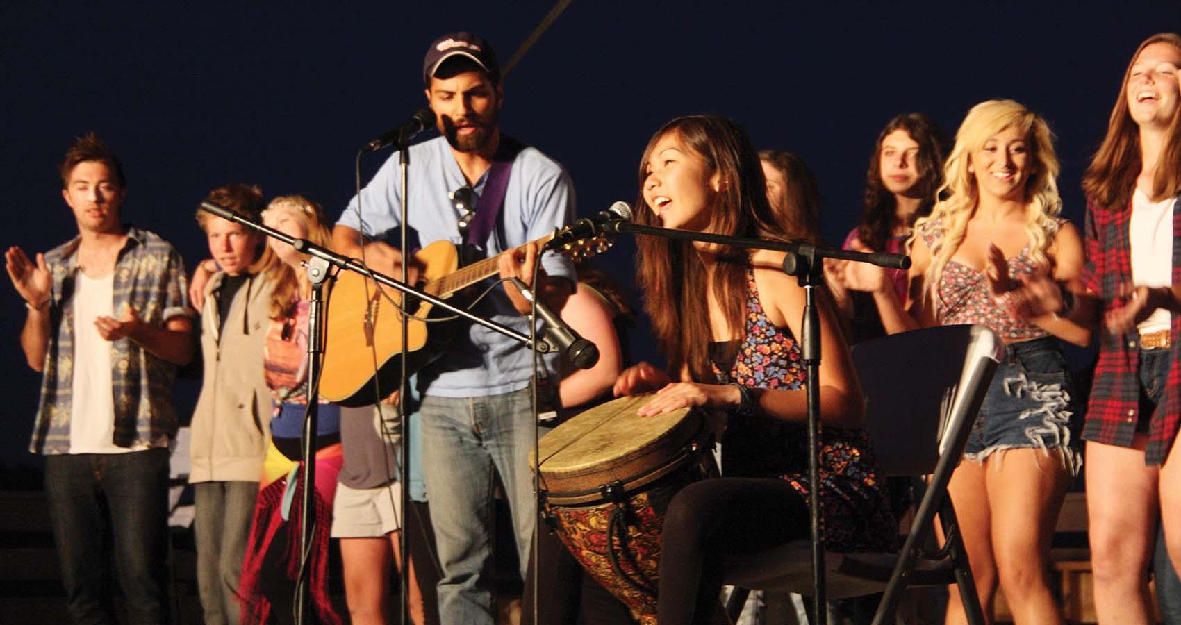 Campers and staff singing and playing music on stage