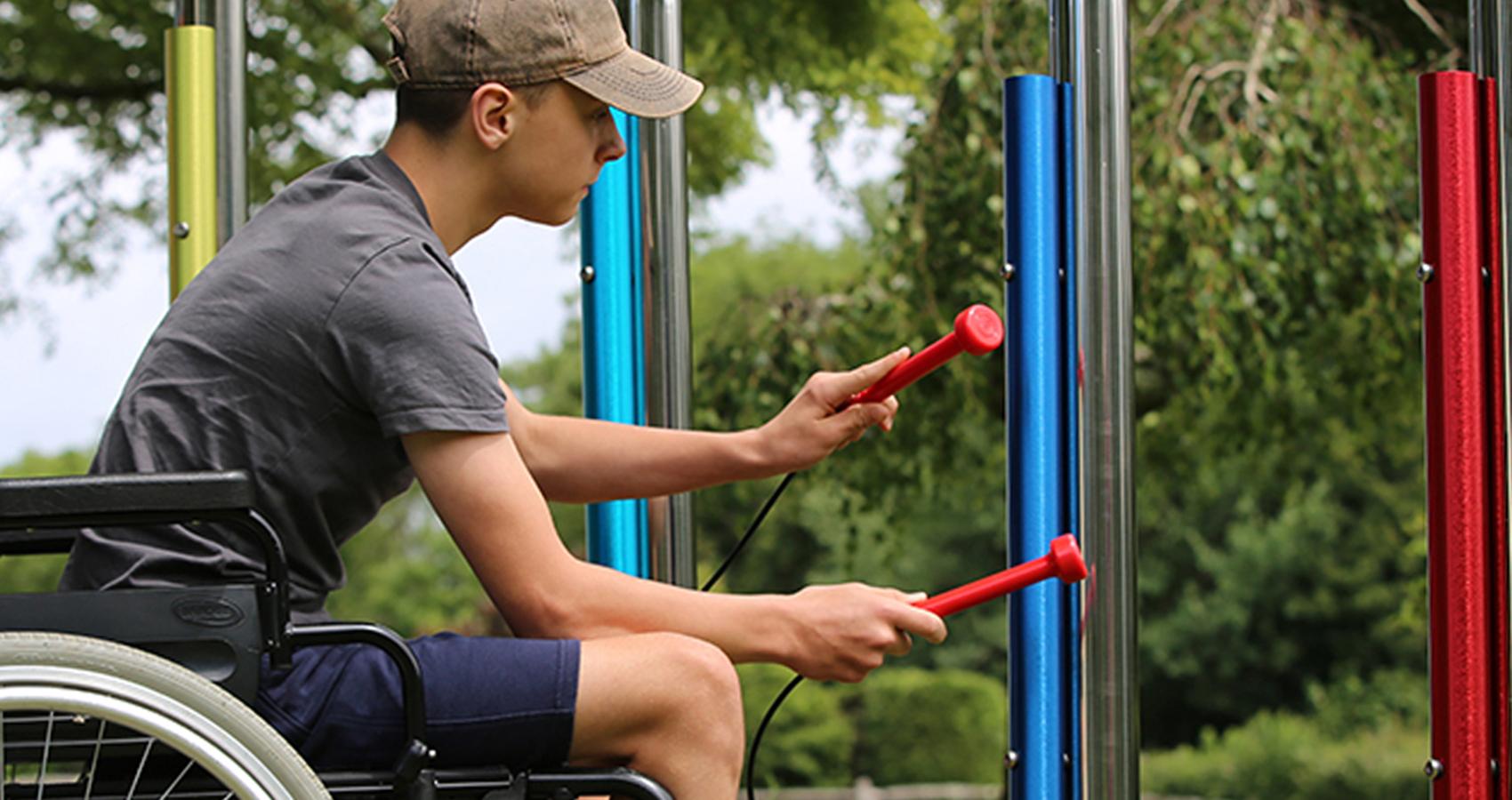 camper in wheelchair playing instrument