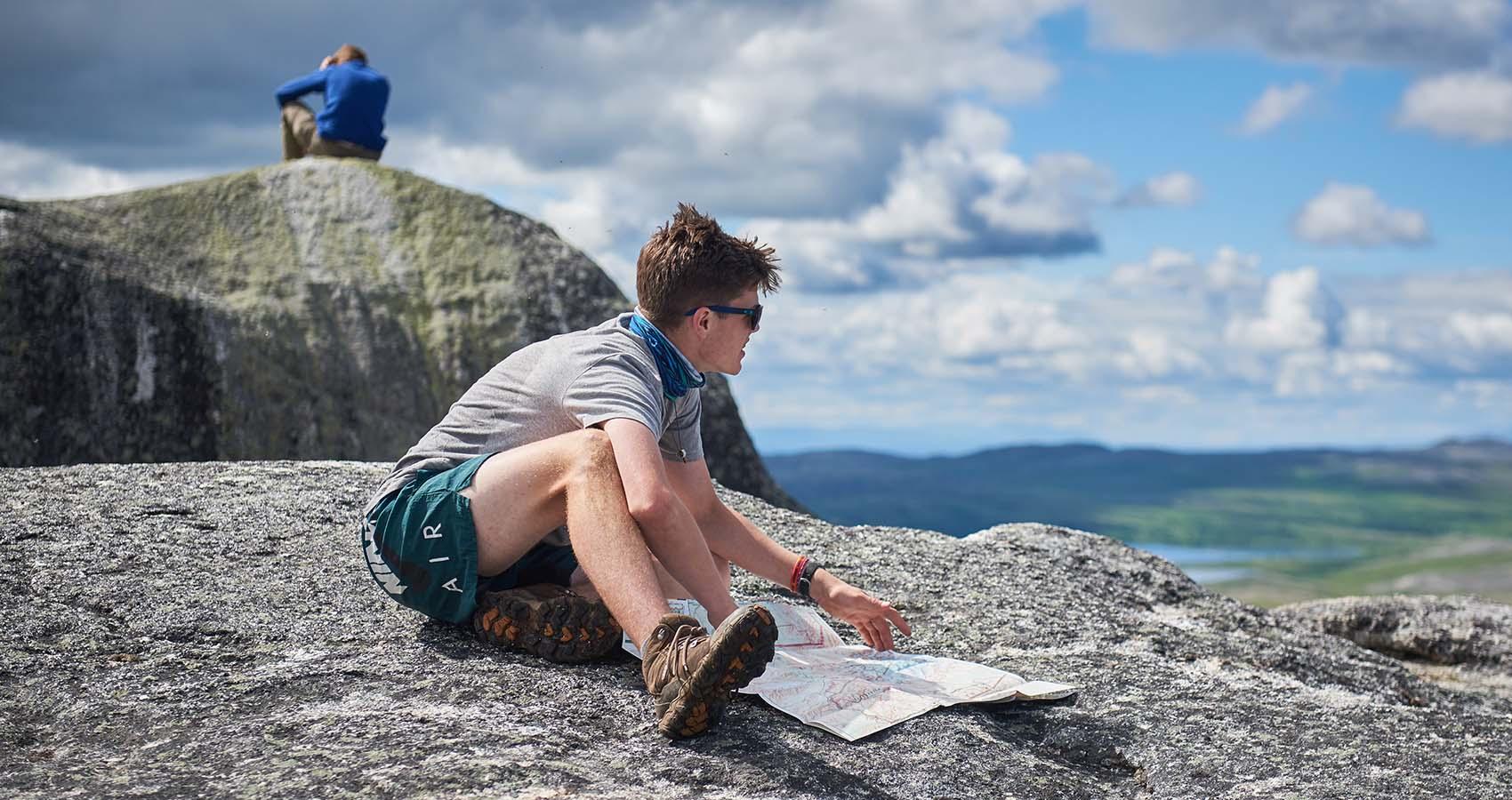 Camper reviewing trail map on top of mountain