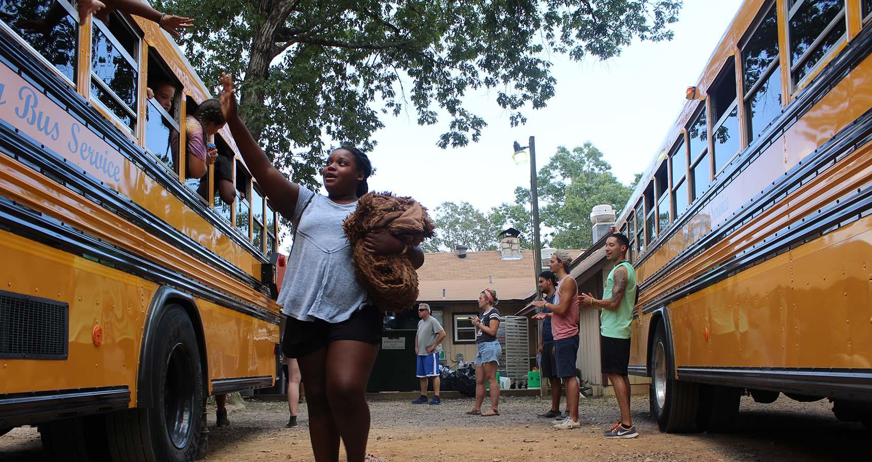 Camper waving to other campers on bus