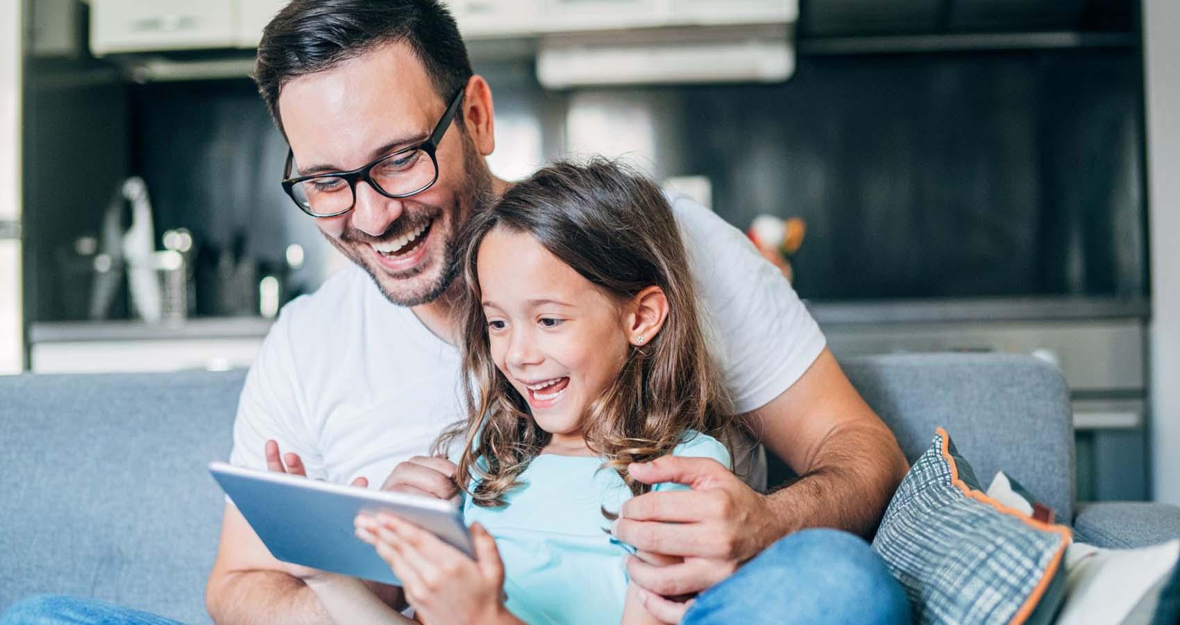 stock photo of father and daughter looking at tablet
