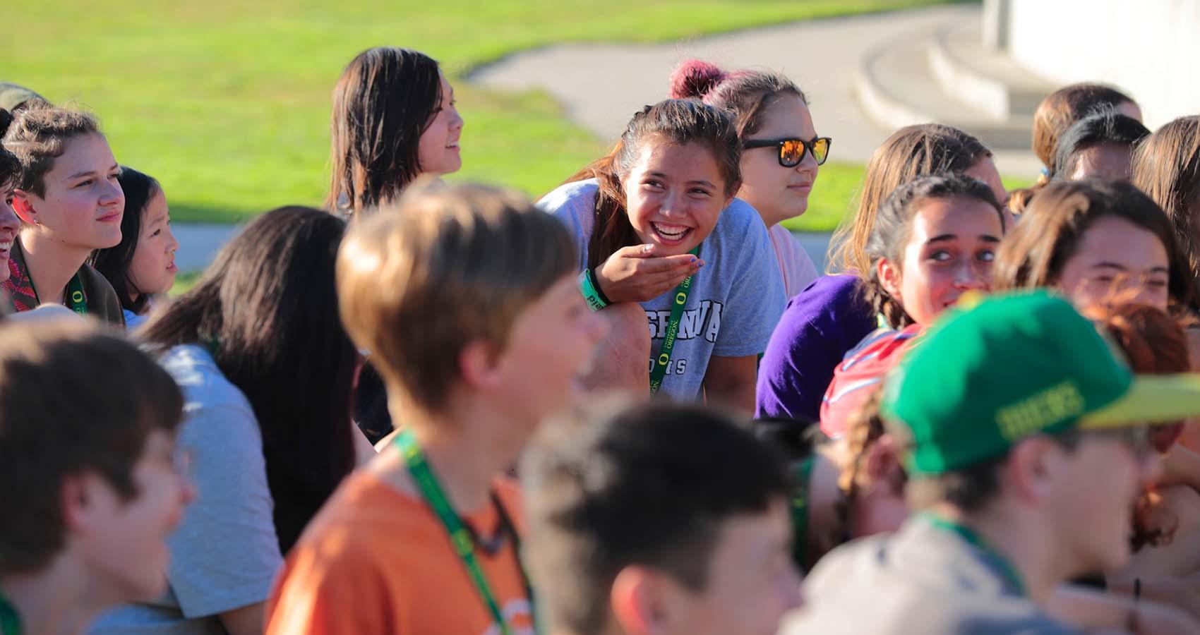 Camper laughing in a group of teen campers