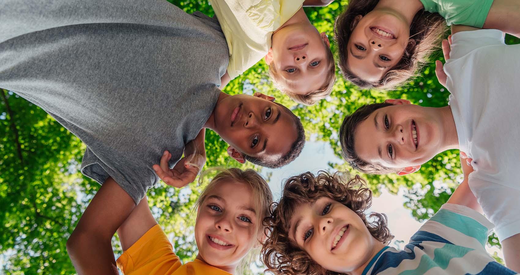 stock photo of kids huddled around camera