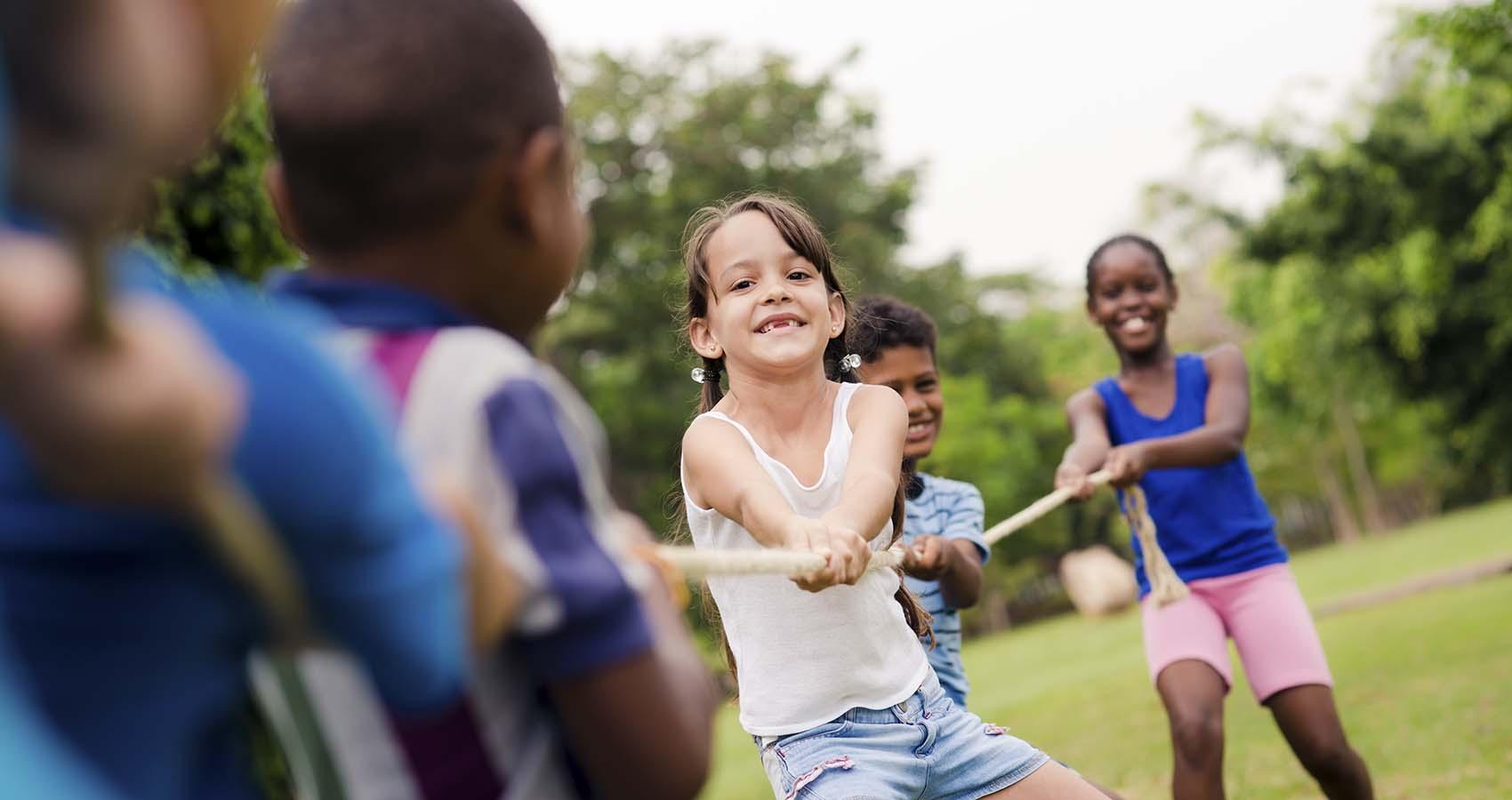 stock photo of young campers playing tug of war