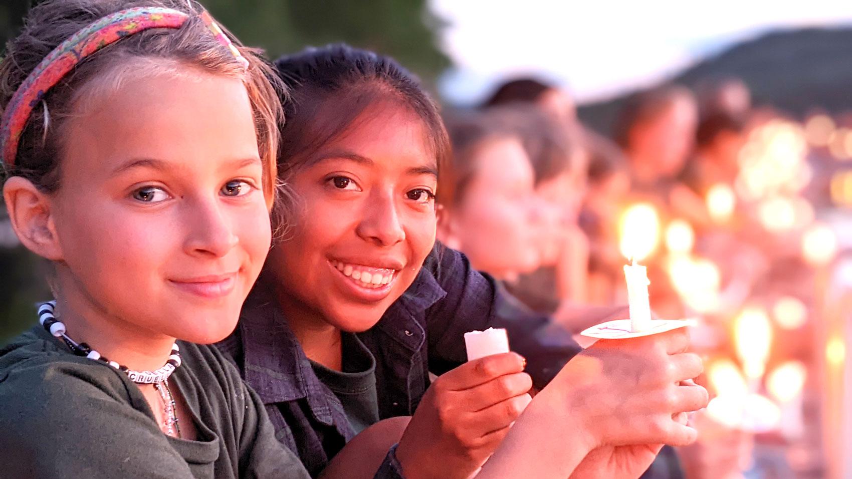 Two Campers with Candles Smiling