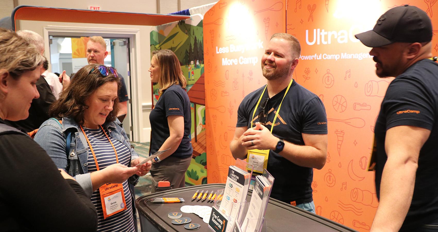 exhibitors talking with attendee