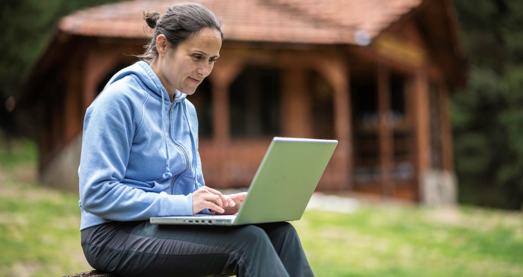 Woman working on laptop outdoors