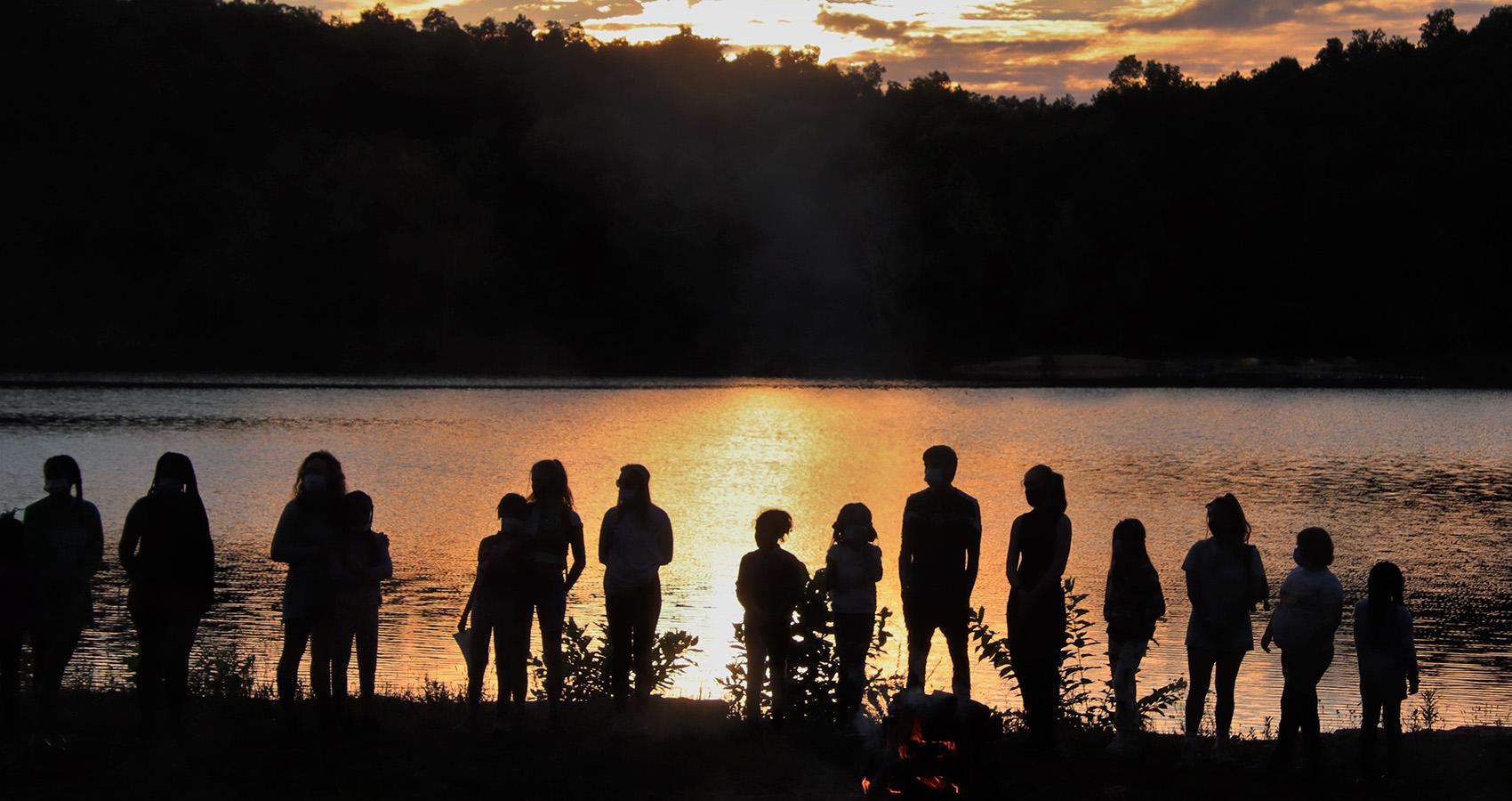 campers and staff silhouettes at sunset