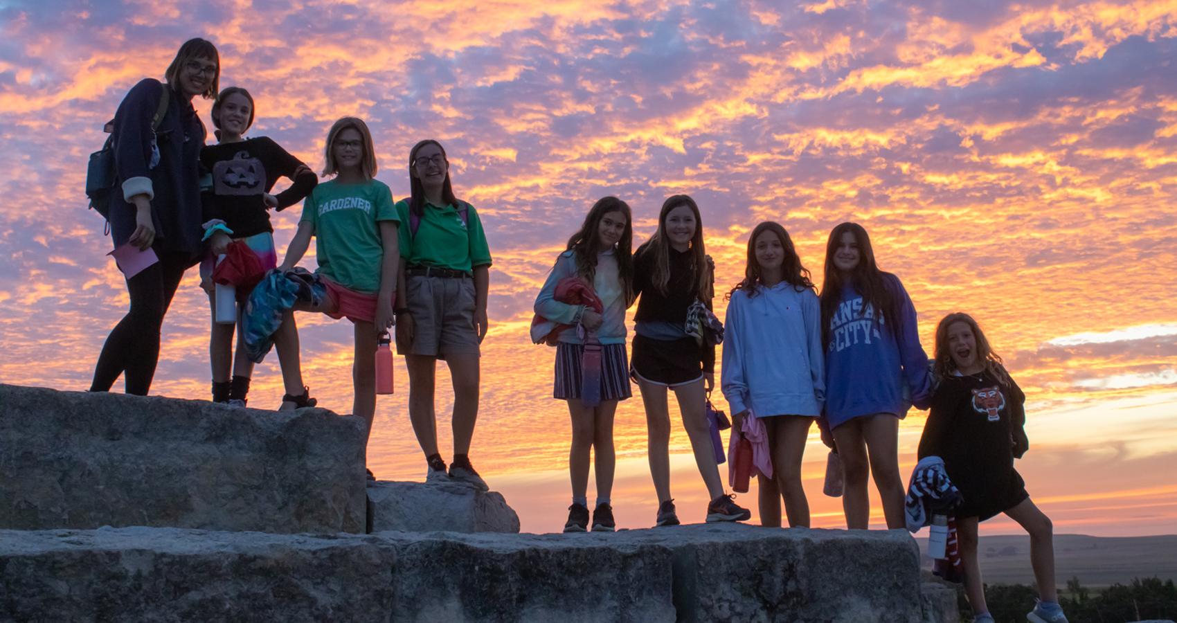 camp group in front of sunset