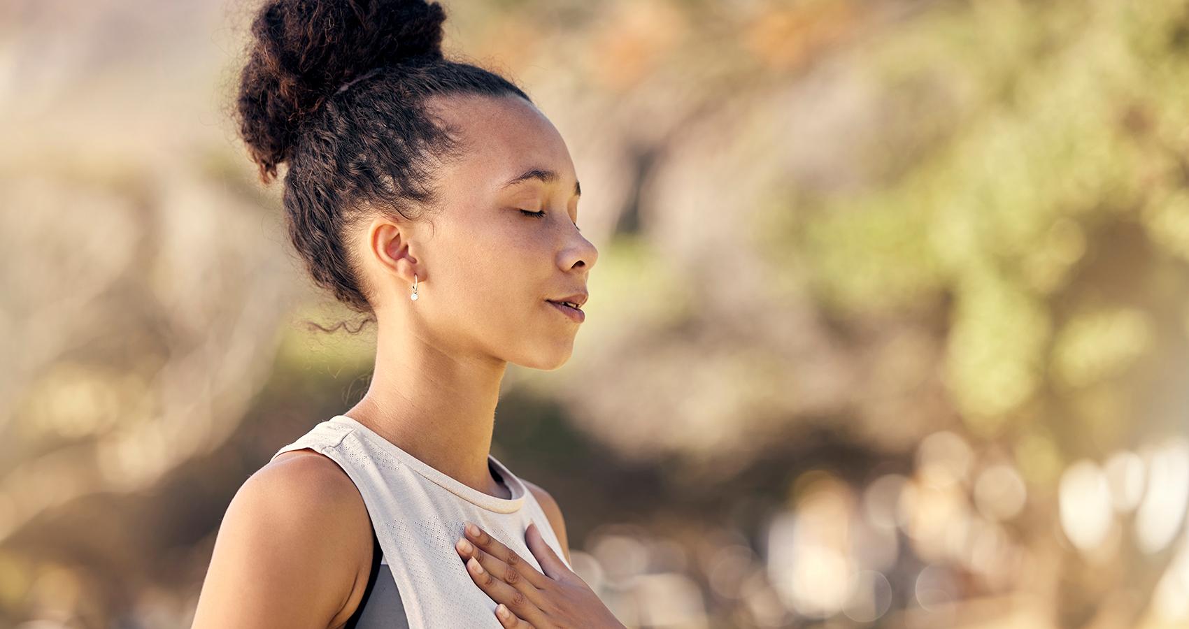 stock photo of person with eyes closed and hand over heart