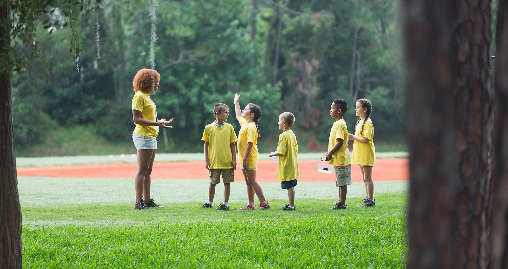 counselor with campers outdoors