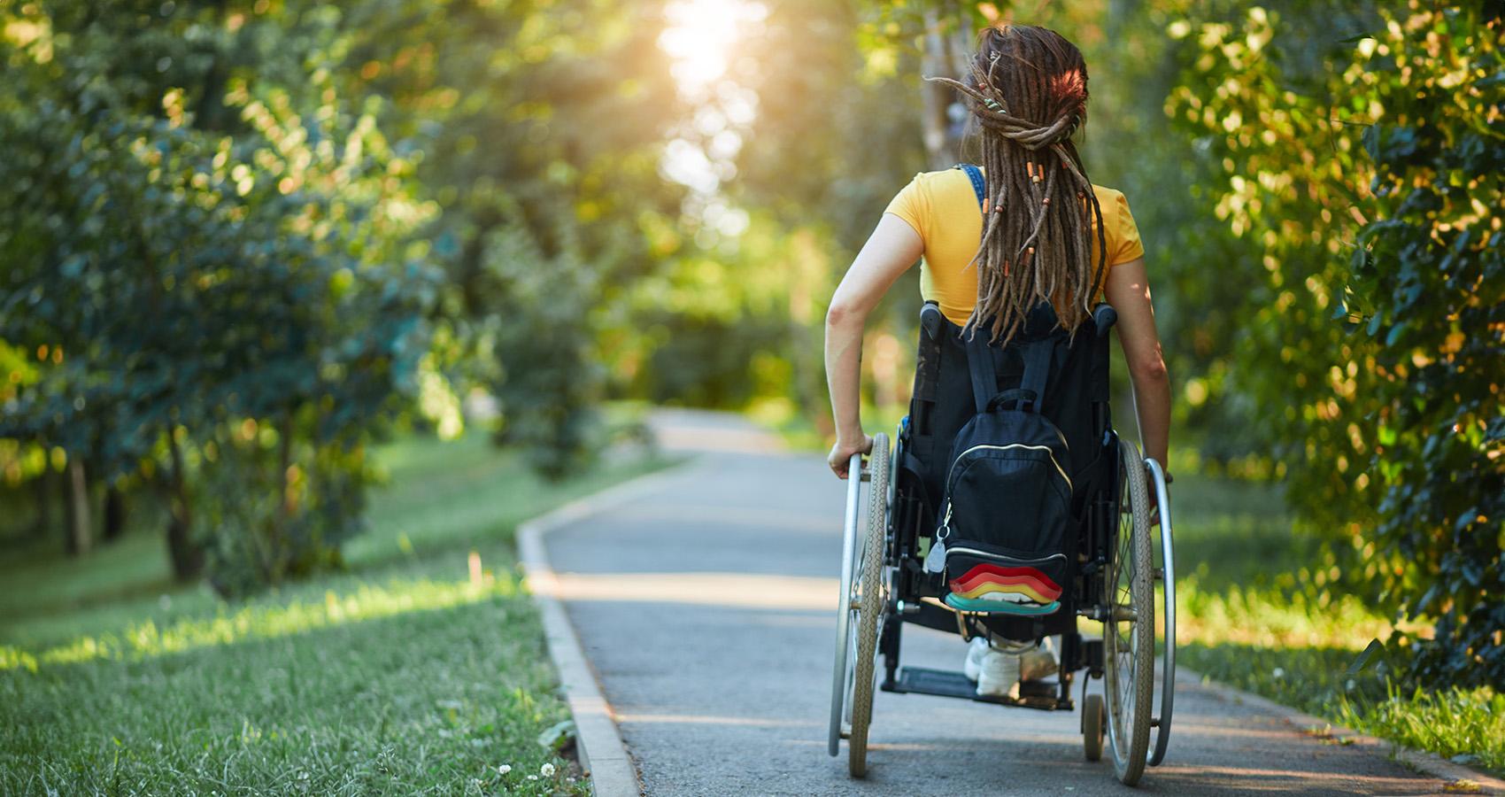 person navigating wheelchair down path