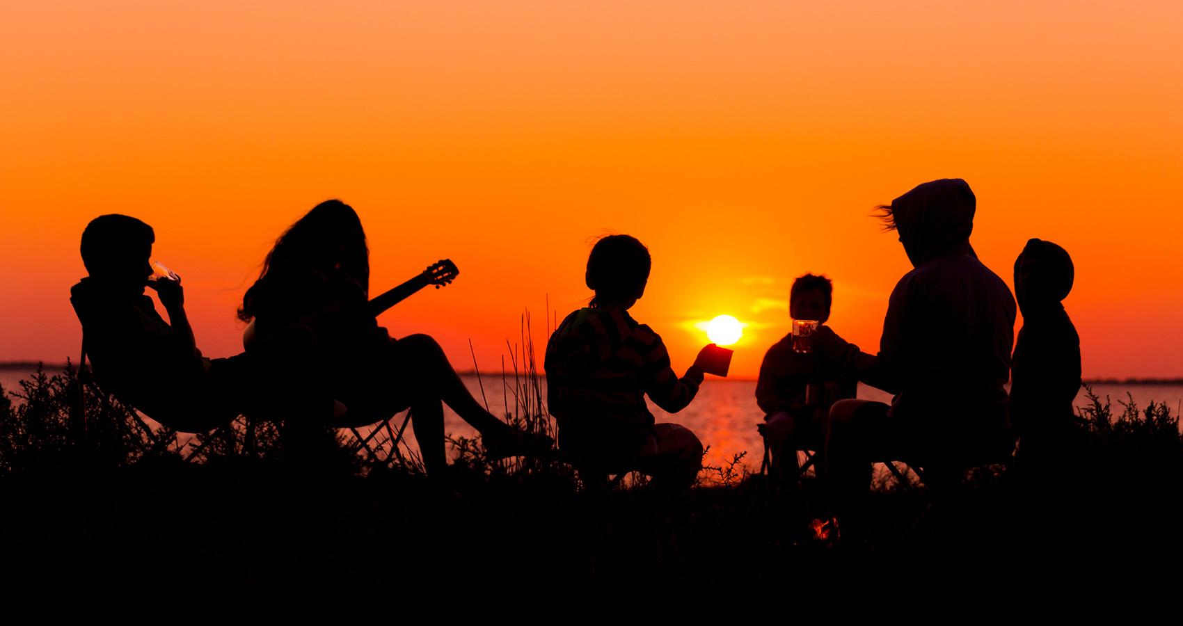 Silhouettes of group of people at sunset