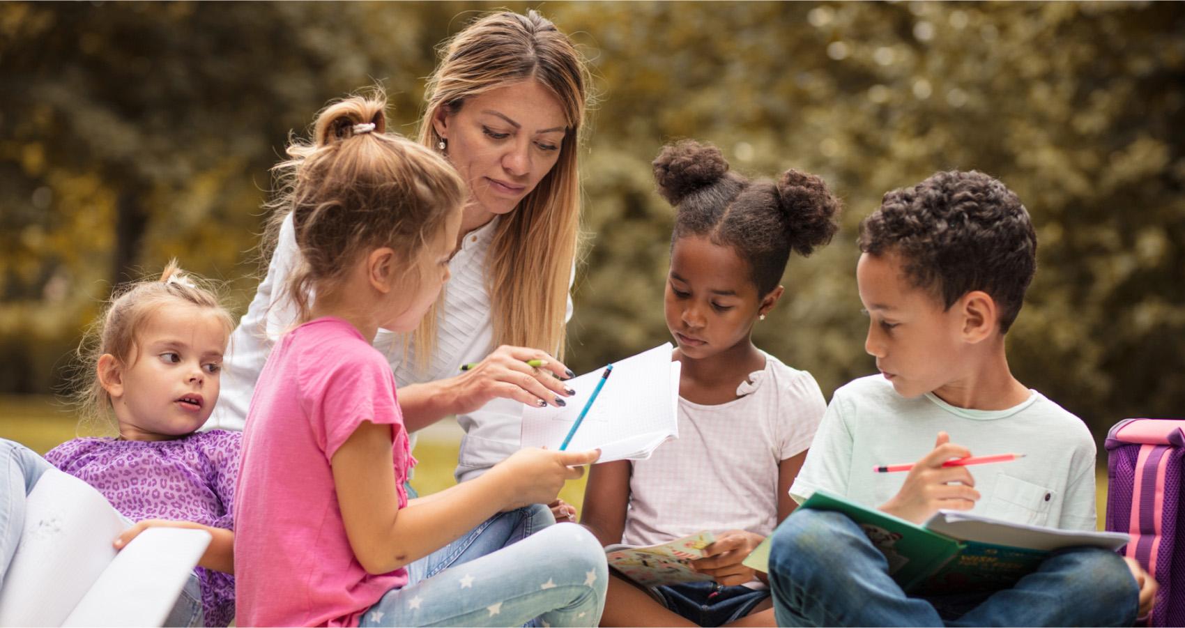 Adult helping children write
