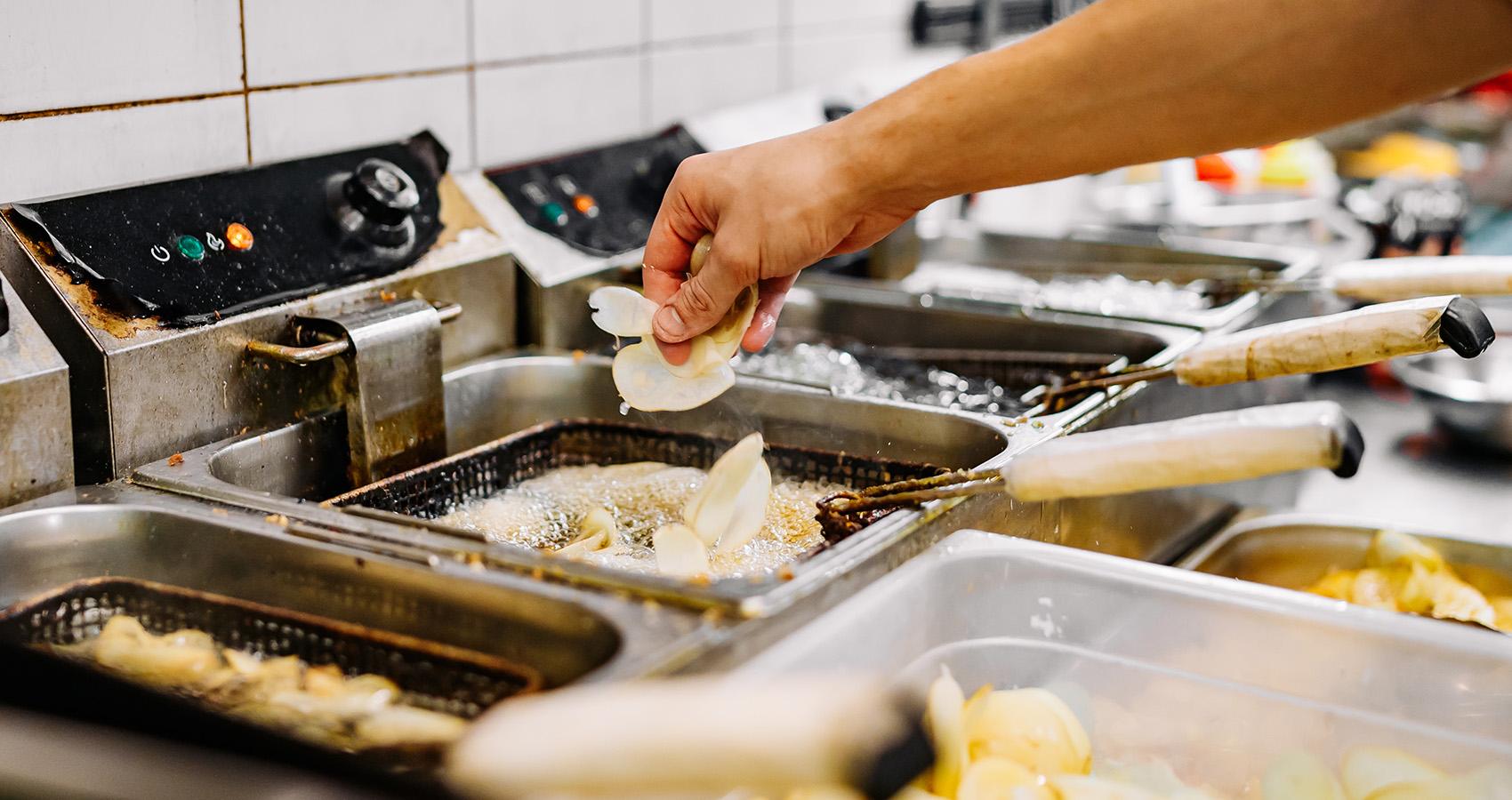 Food getting placed into deep fryer