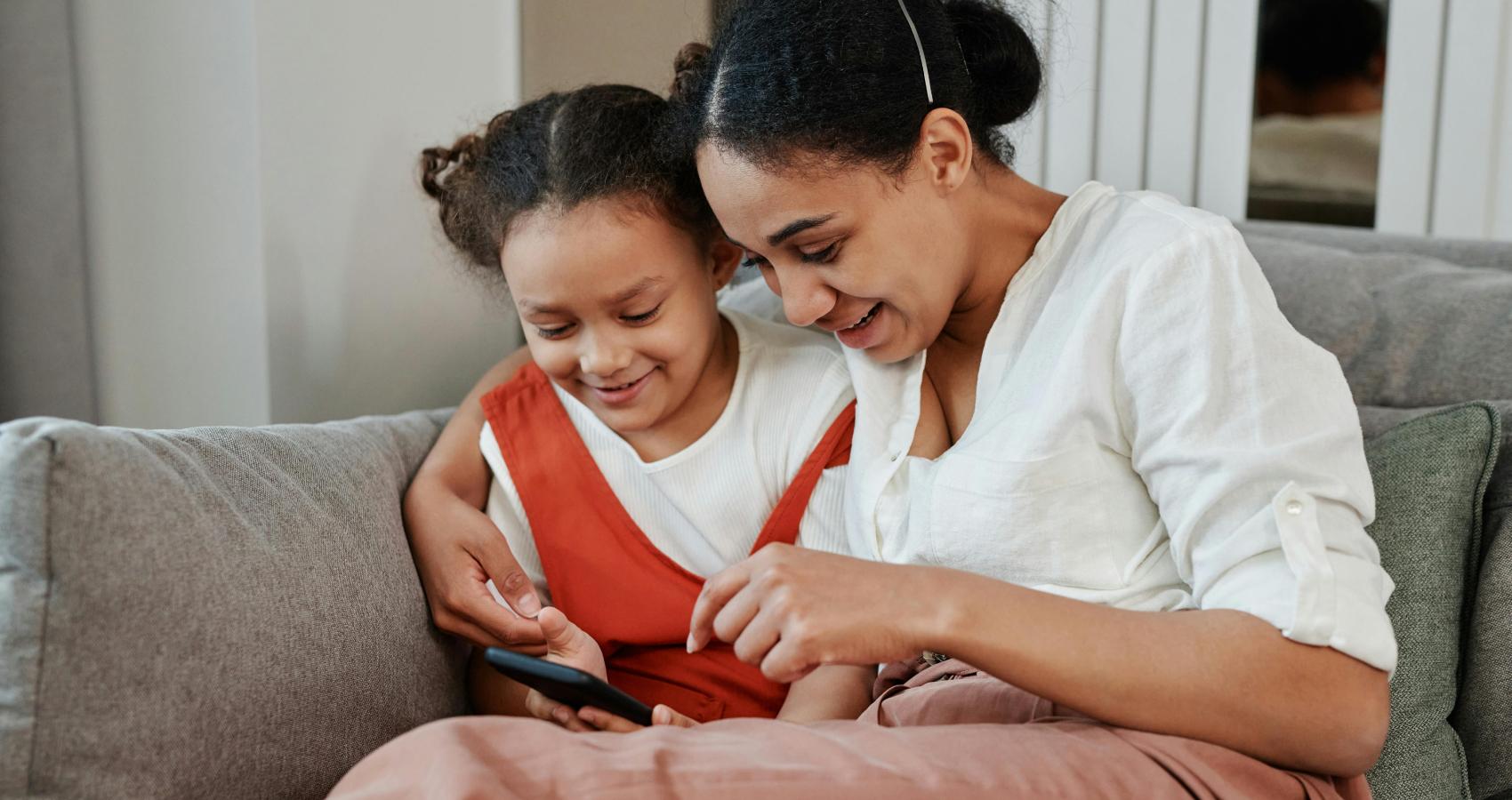 Mother and daughter looking at smartphone together