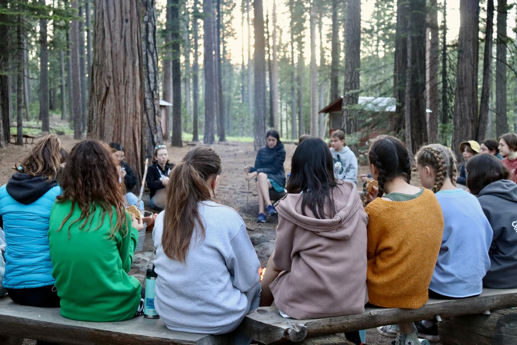 campers sitting around fire