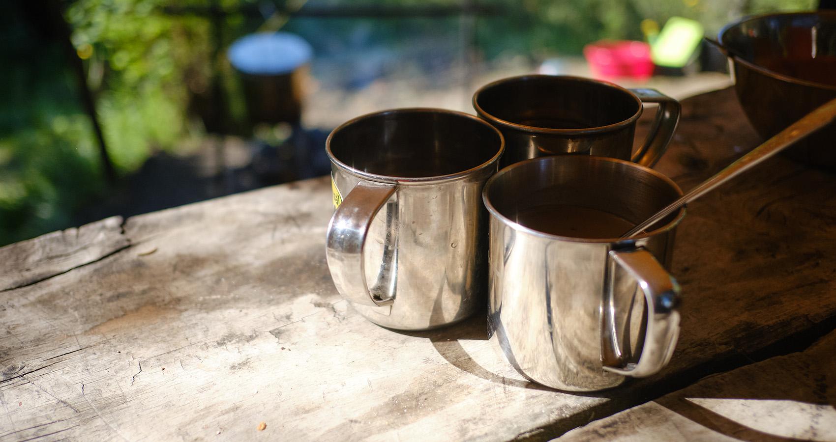 metal camping coffee cups on table