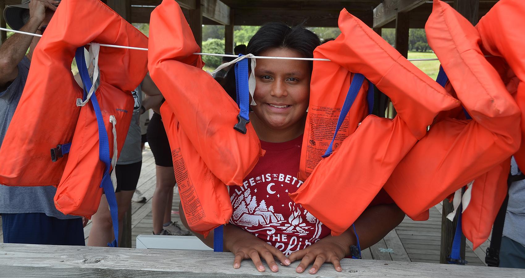 person at camp behind line of life preservers