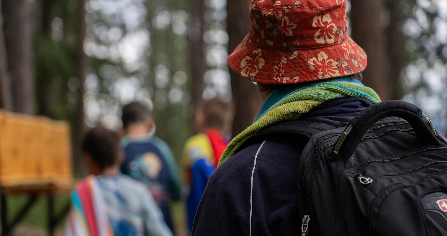 person wearing bucket hat and campers in background