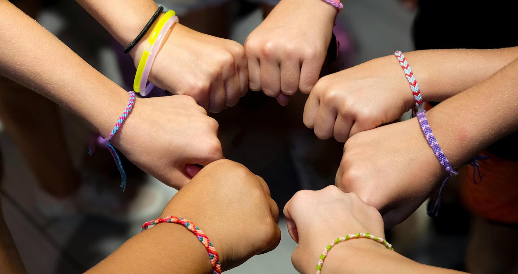 campers putting their hands in a circle