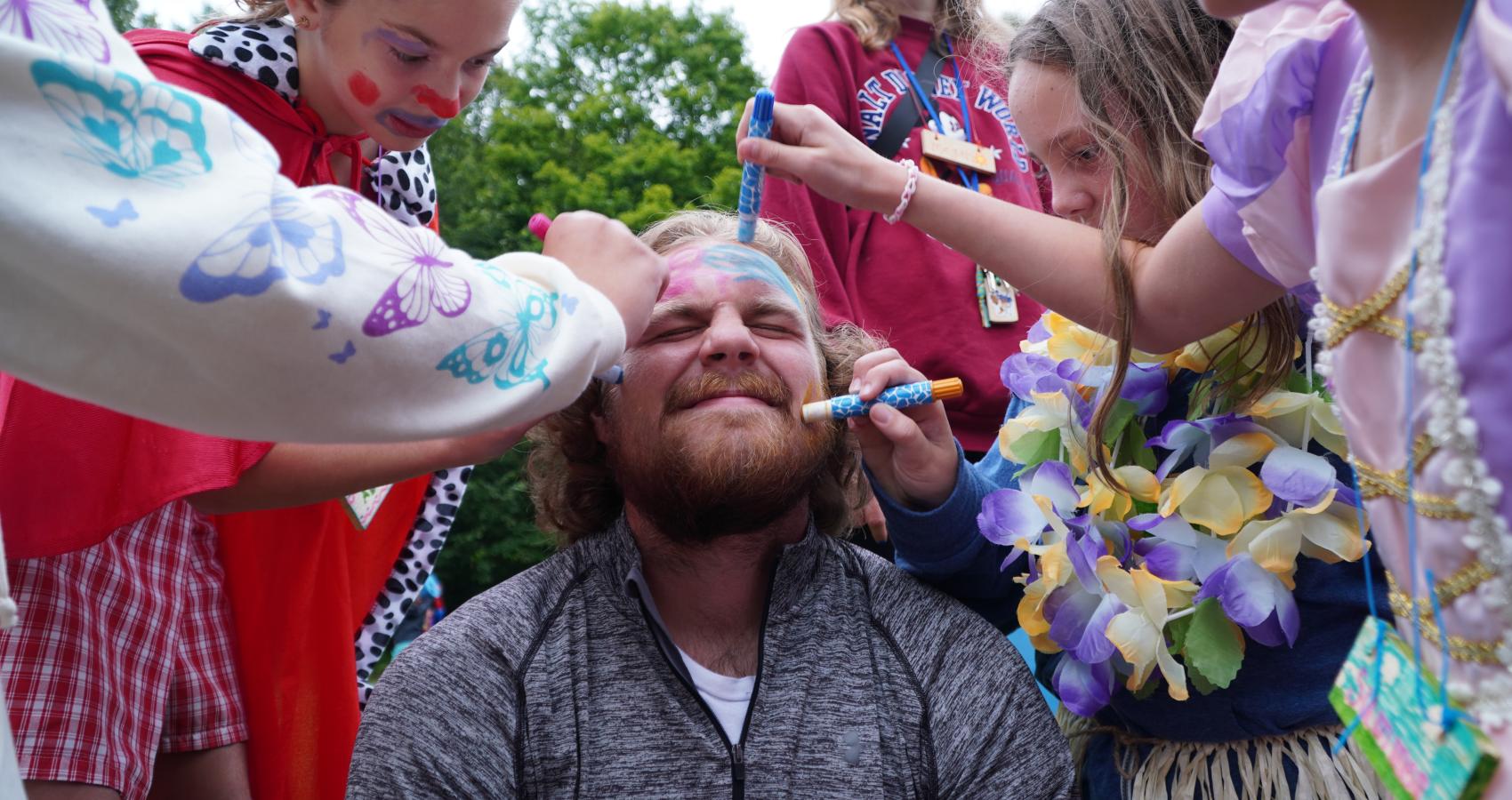campers drawing on staff member's face