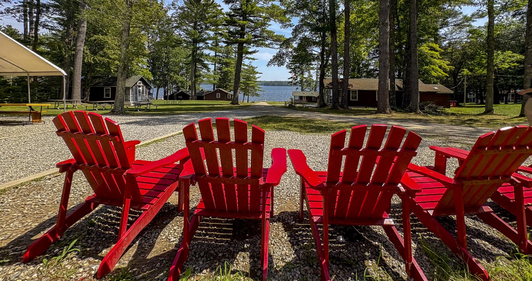 red adirondack chairs with camp in background