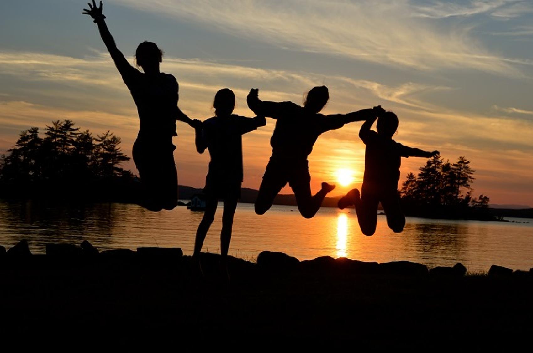 campers jumping at sunset