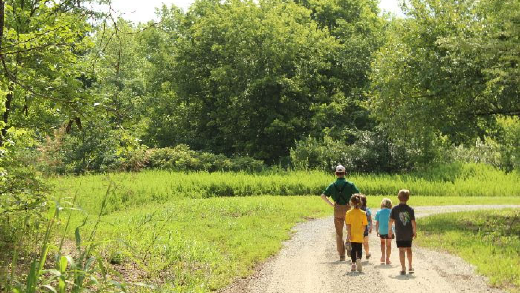 Campers and staff person walking on path