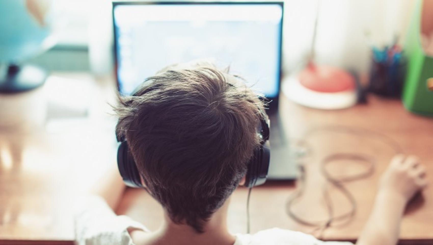 child using computer and wearing headphones