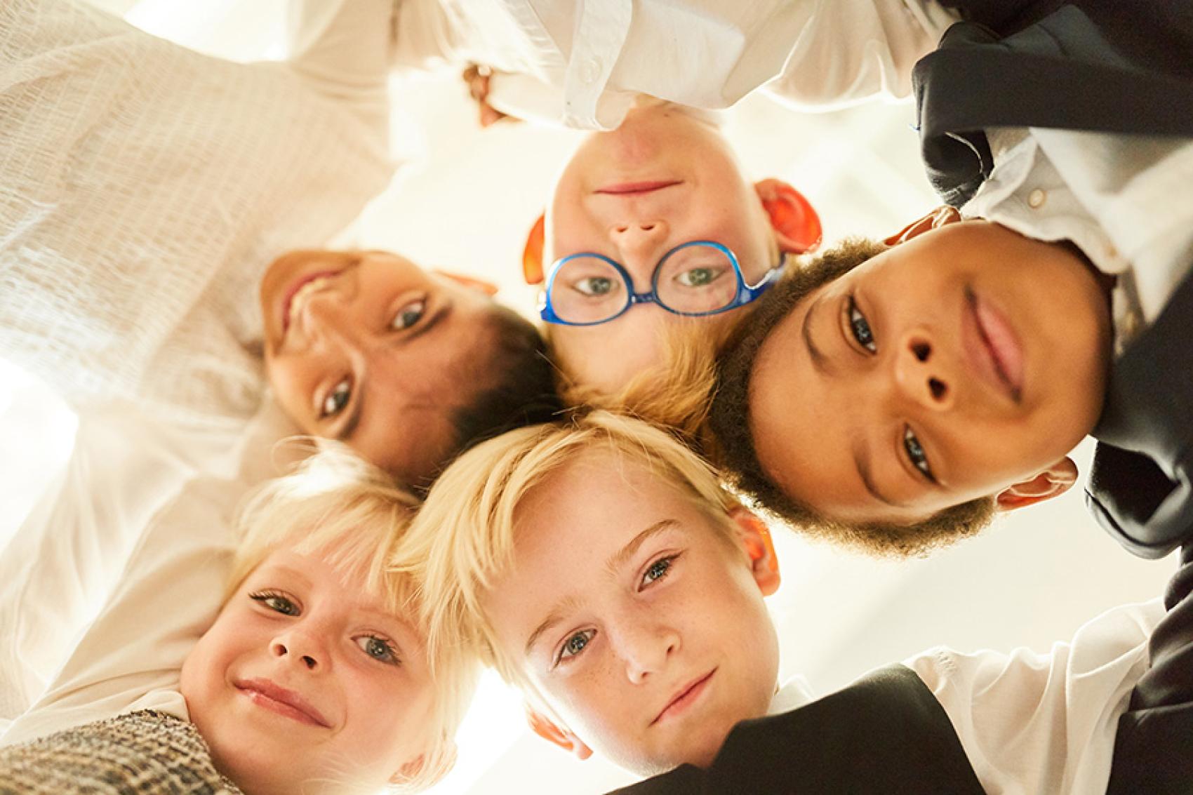 stock photo of kids huddled facing down at camera