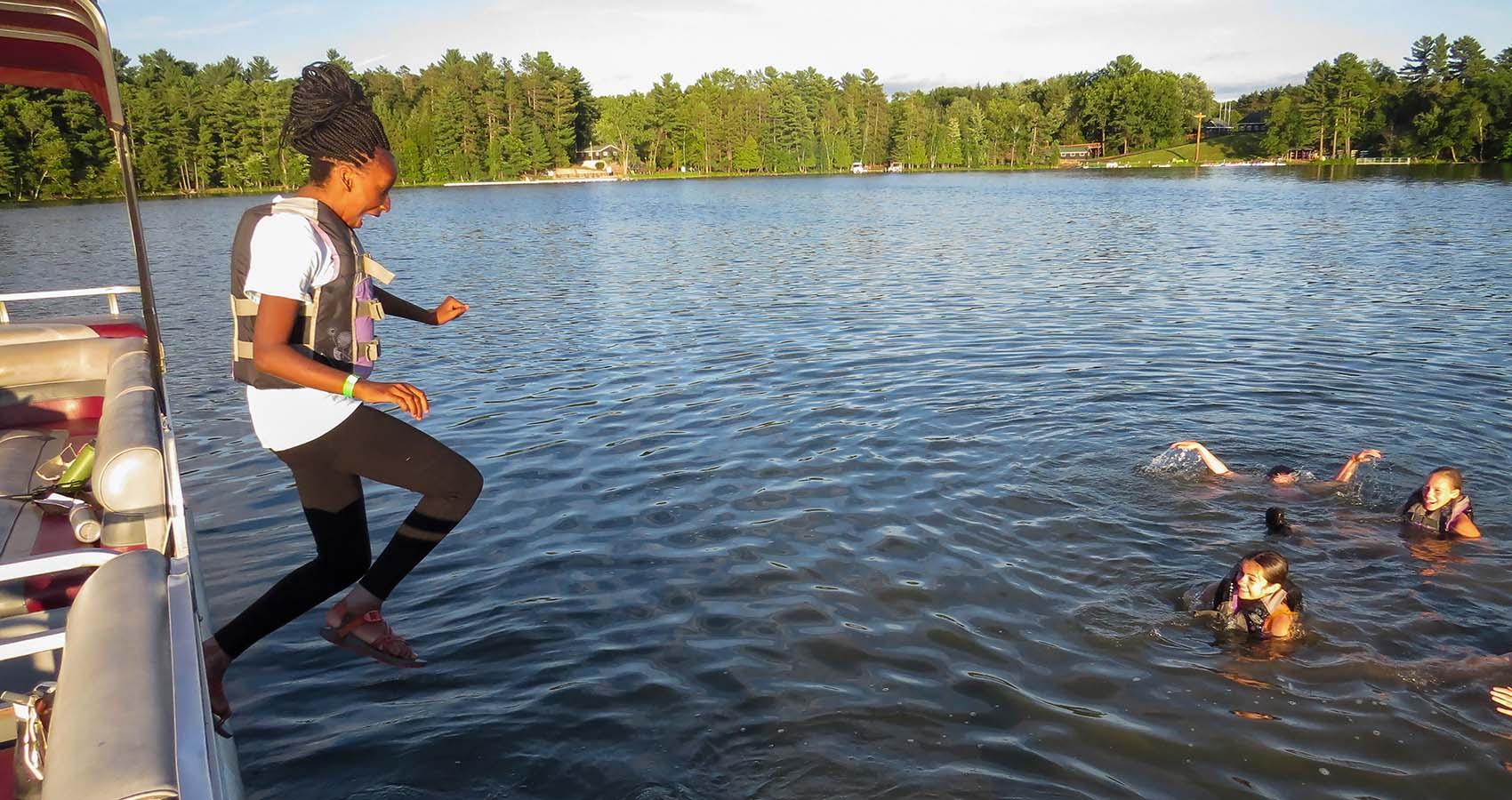 camper jumping into water